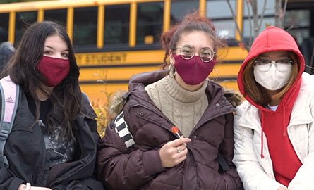Three students outside, wearing masks 