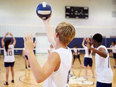 male student playing volleyball