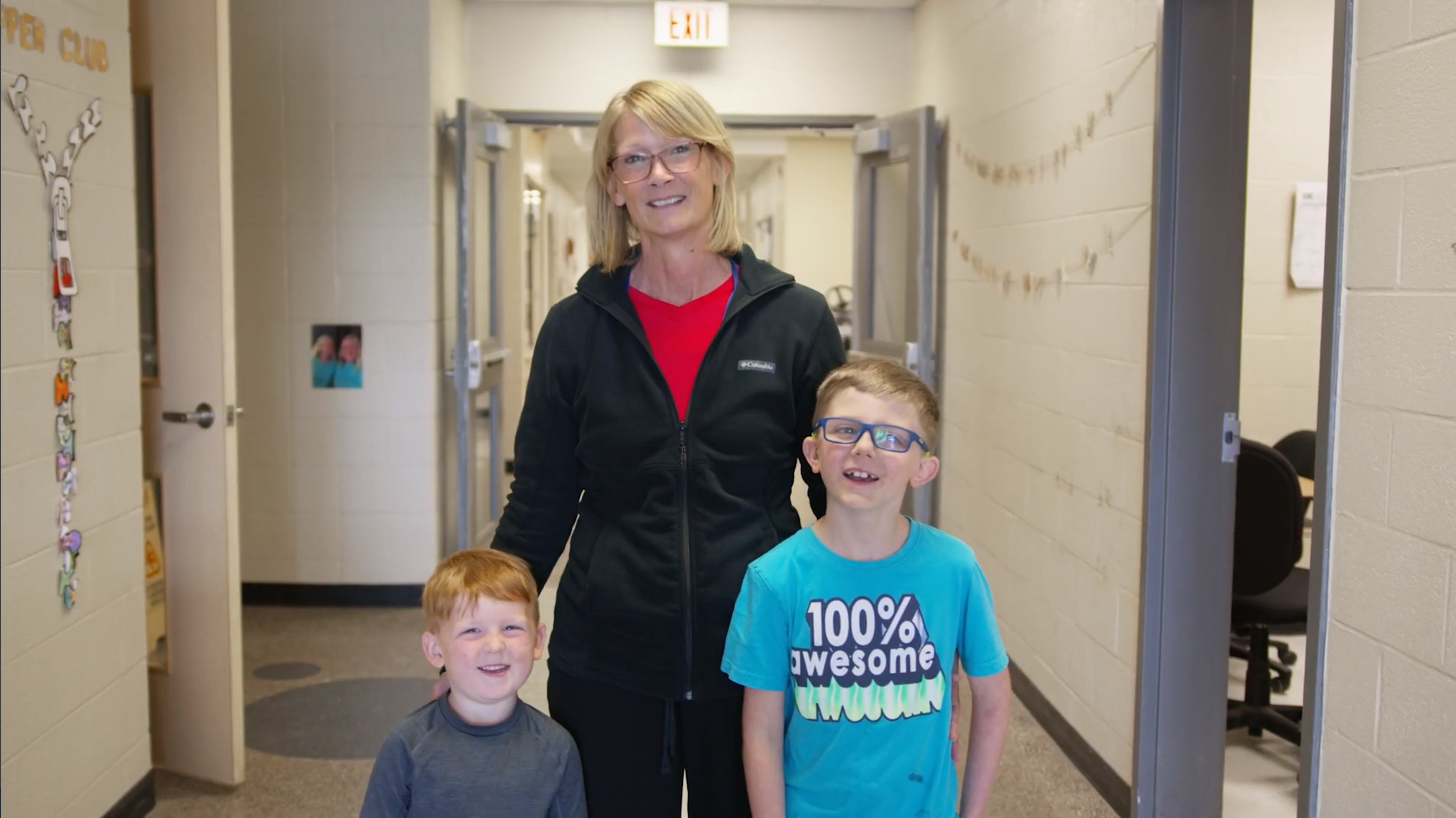 Custodian with two students in hallway 