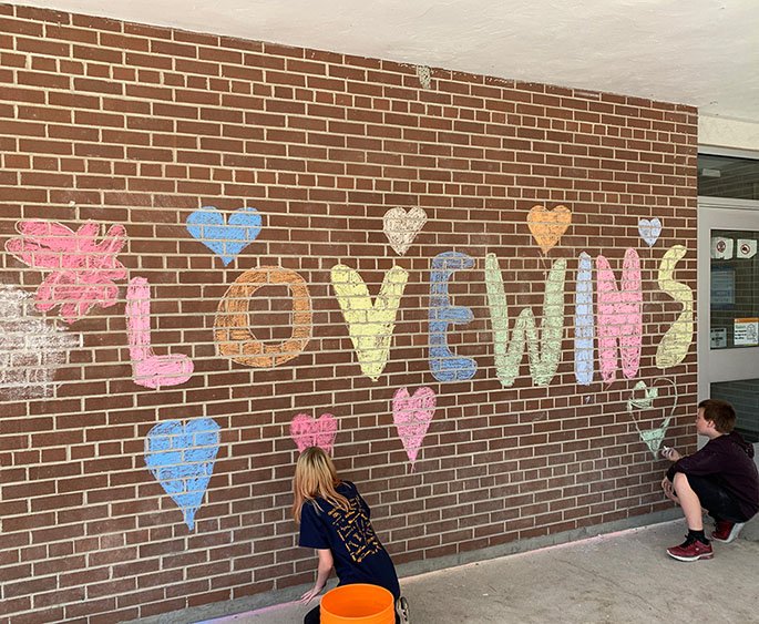 chalk picture on school walls with words "love wins"