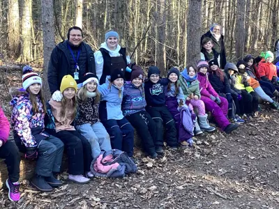 a group of students outside in the woods