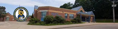 exterior picture of Baltimore Public School and their logo