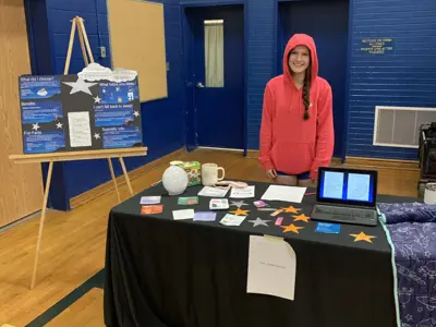 Student standing behind an information booth