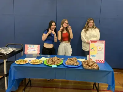 Students standing in front of table with baked goods on it
