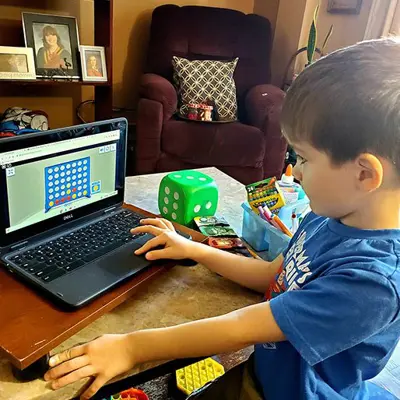 Picture of young student working on laptop at home